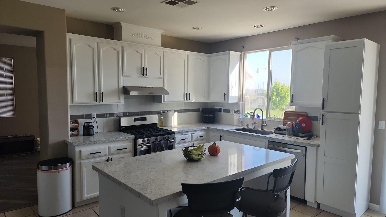 Completed bright kitchen remodel with white cabinets and island